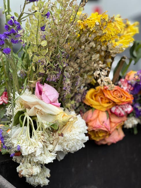 A diverse arrangement of fresh flowers displayed for delivery, featuring white and pink lilies with large, delicate petals, clusters of white carnations with ruffled textures, purple statice and limon
